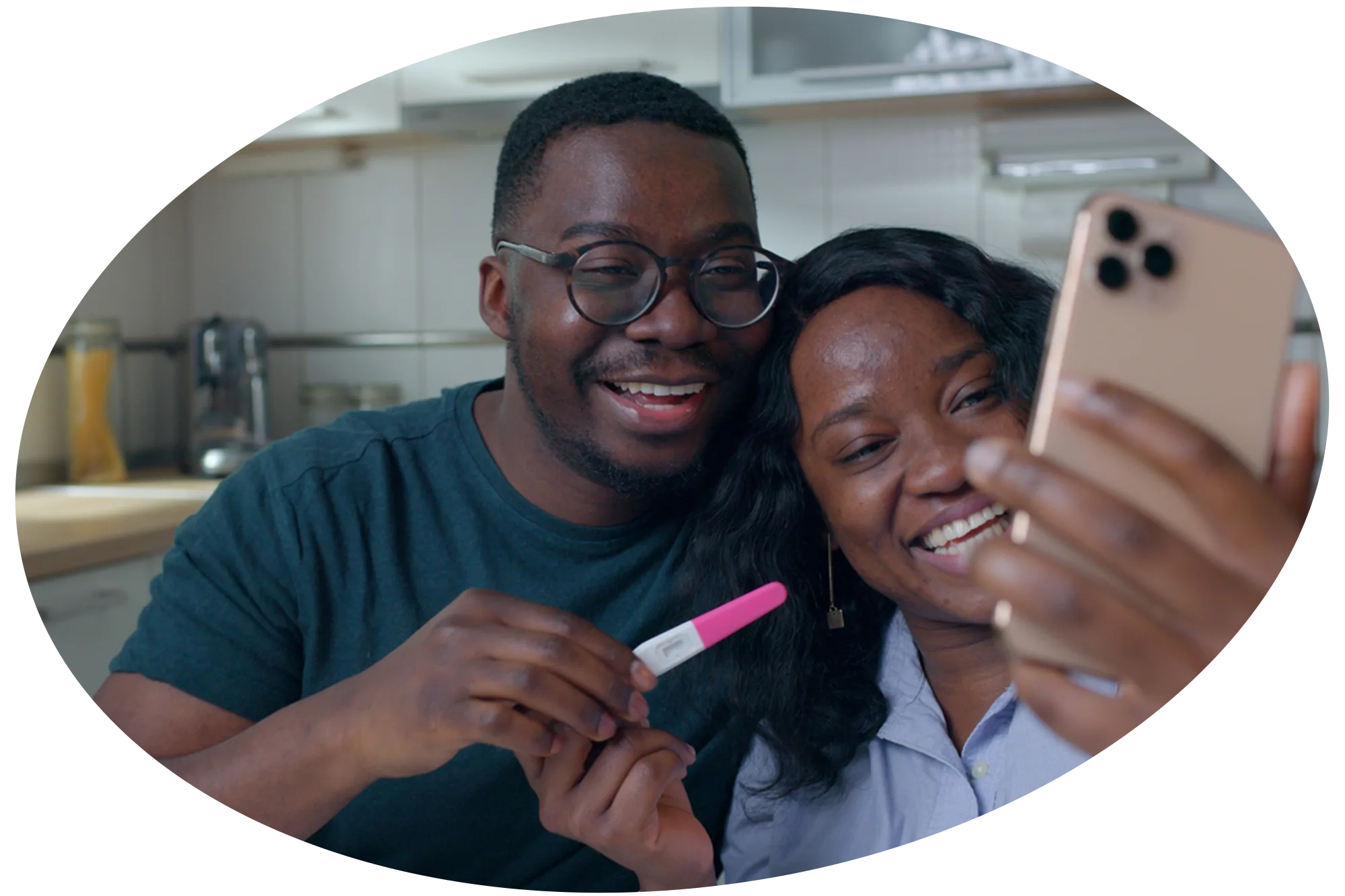 Photo of an African American couple taking a selfie while holding a positive pregnancy test.
